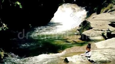 小女孩躺在石头上晒日光浴自然山<strong>河池</strong>塘与瀑布